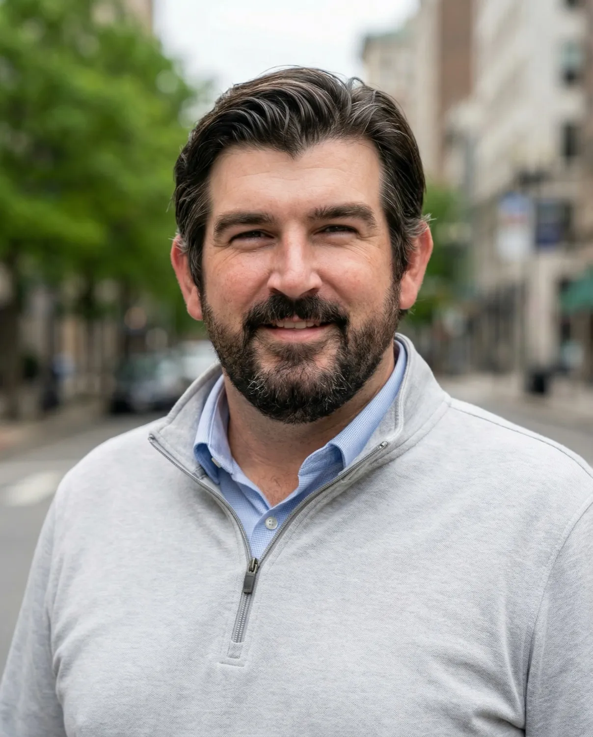 Andy Janaitis, photographed outdoors on a tree-lined city street.